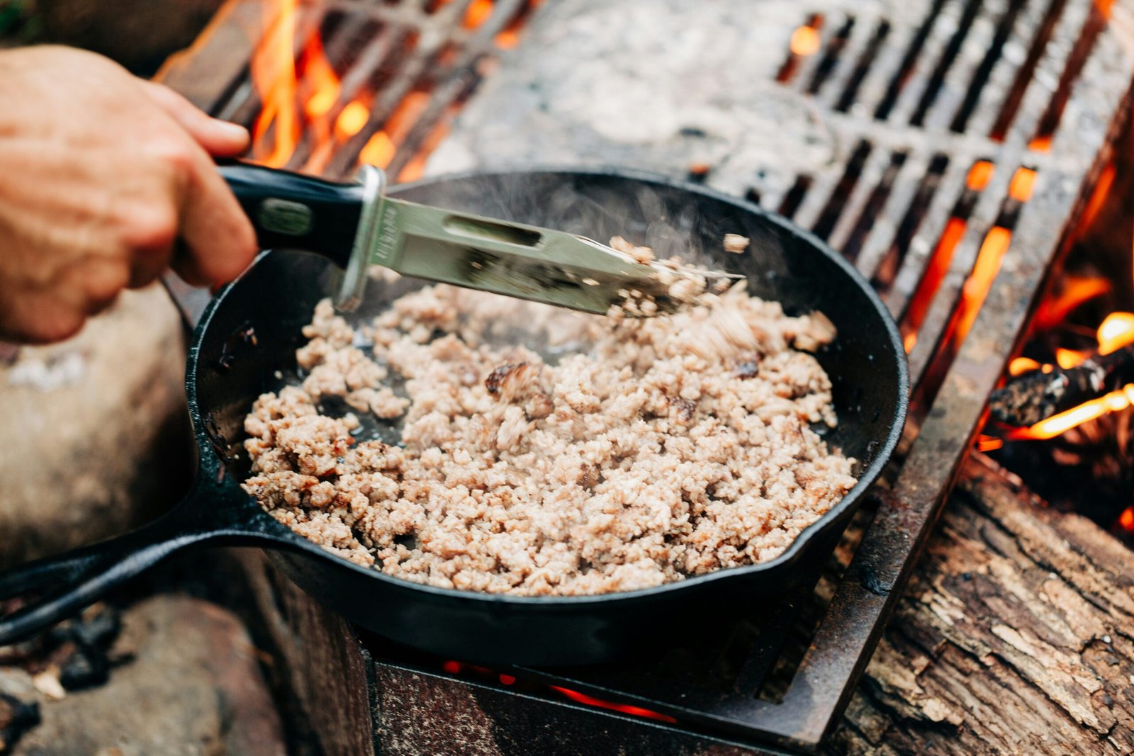 person holding black frying pan with rice